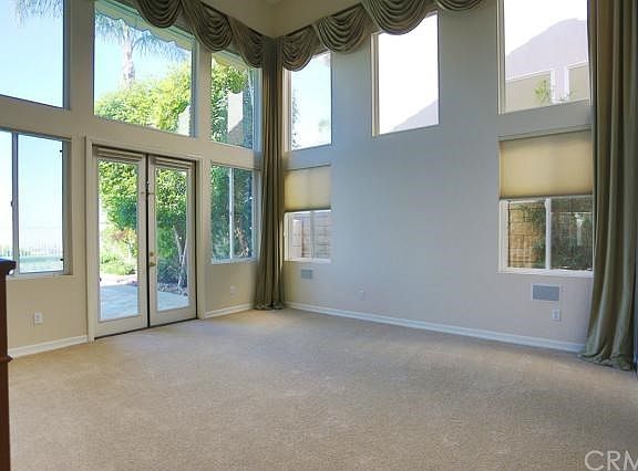 Formal living room with 2 story ceilings and lots of windows as well as brand new carpeting and drapes.