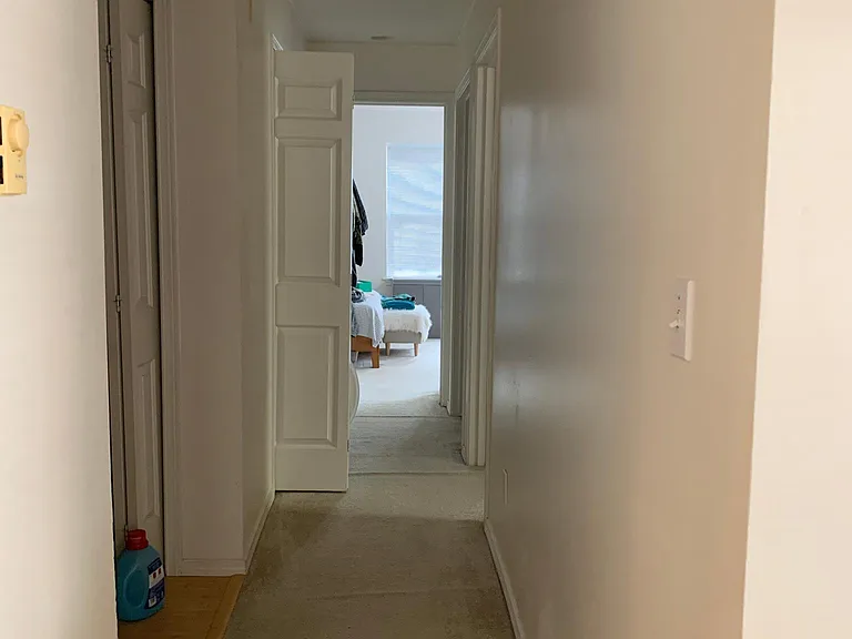 Hallway connecting living space to bedrooms (end & right), bathroom (second door on right), entry way & laundry closet (on left)
