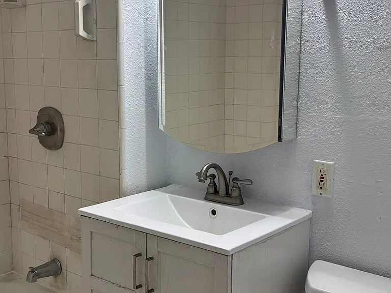 Bathroom restored with new cabinets, mirror and lighting!
