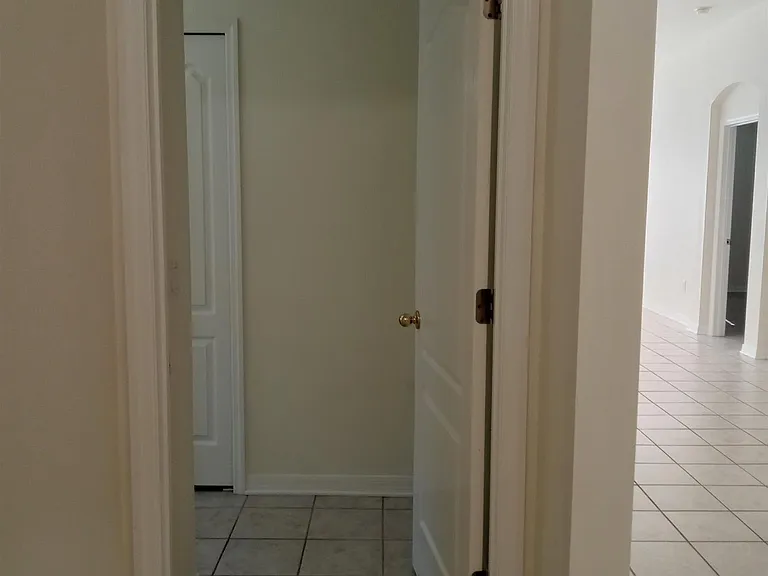 Front hallway view looking to the guest bath doorway. The front doorway and laundry room are to the right.