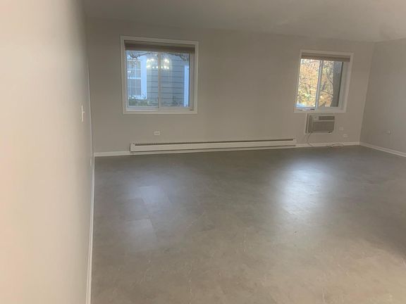 Large sunny living room! This room features custom thermal window treatments look out on lots of trees and sunlight to the east. Also windows looking west and south views from bedroom and kitchen. Freshly painted and calked. Electric heat. Bright, s