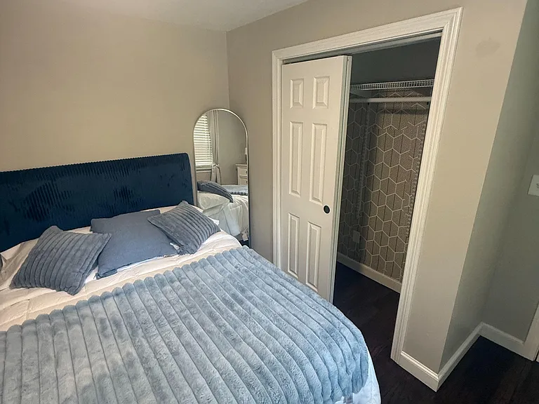 Furnished bedroom with a full bed, soft linens, and an in-room closet for convenient everyday storage.