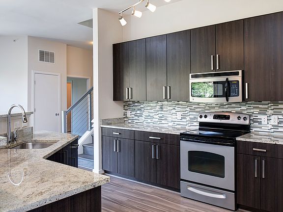 Modern kitchens with granite countertops, stainless steel appliances, and tile backsplash