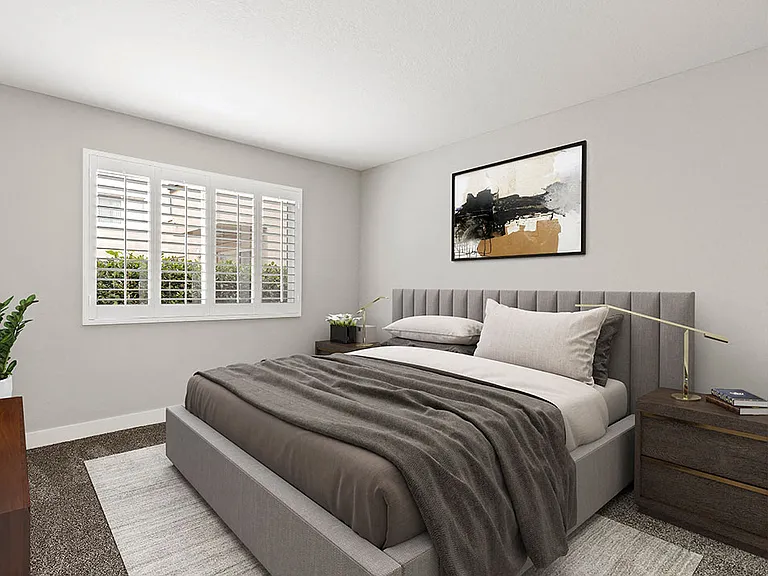 Carpeted bedroom with large natural light windows.