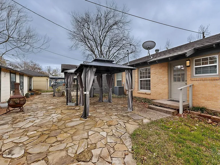 An inviting backyard with a gazebo and a patio, perfect for outdoor gatherings and enjoying nature.