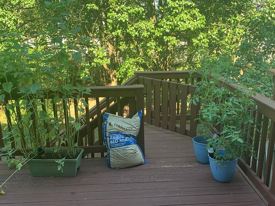 Oversized deck for outdoor living with stairs to fenced yard.