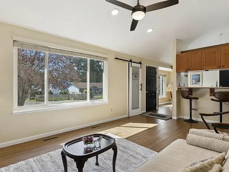 Living room with ceiling fan and large window.