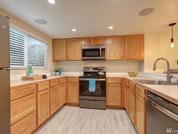 Updated kitchen with stainless steel appliances and new lighting.