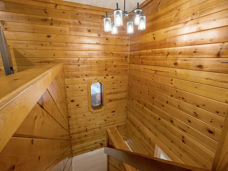 Stairs to private primary suite with full bath and entertainment area.