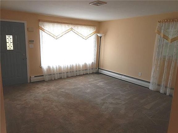 Large carpeted living room with bay window