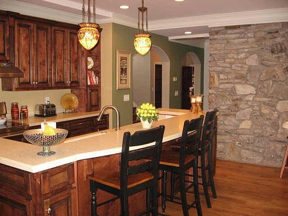 Gourmet kitchen features custom built cabinets and tiffany style lighting