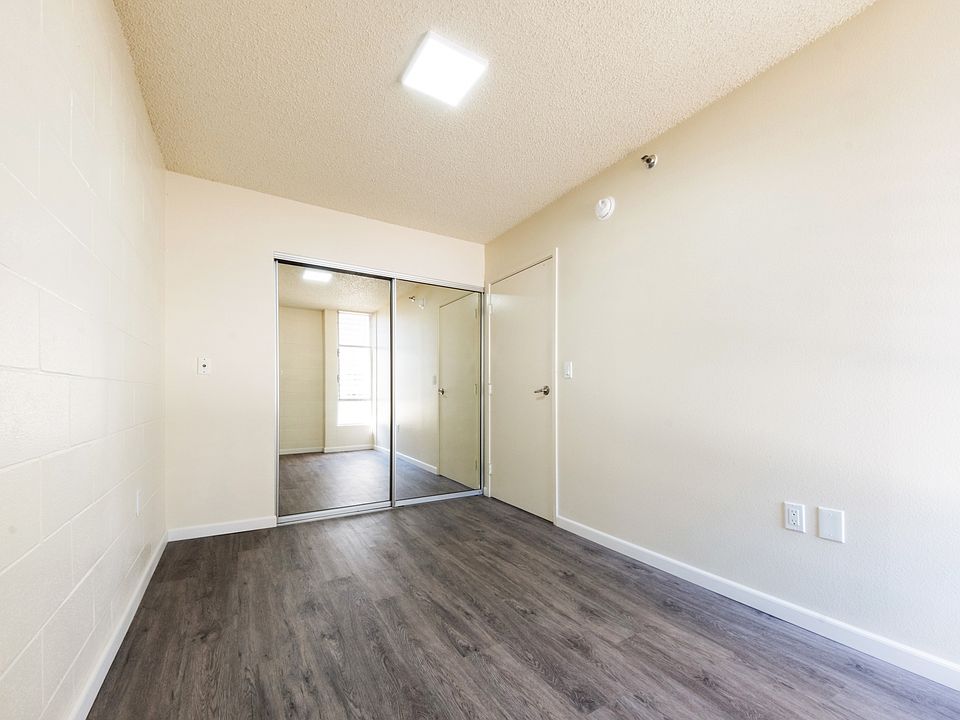 This bedroom offers a clean, modern look with mirrored closet doors and ample storage.