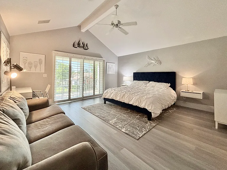 Upstairs primary bedroom with king bed and balcony overlooking the lake