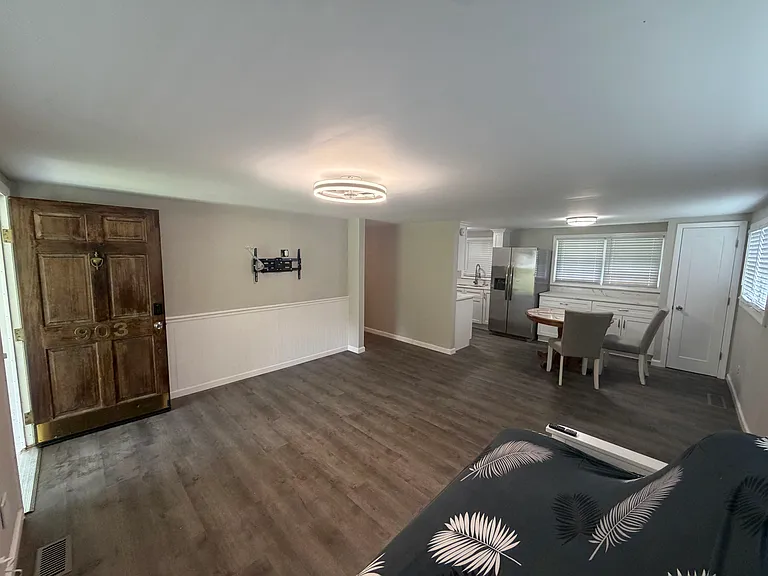 main living area with wainscotting and large tv mount. New LVP flooring throughout house.