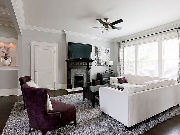 Spacious living room features windows and fireplace