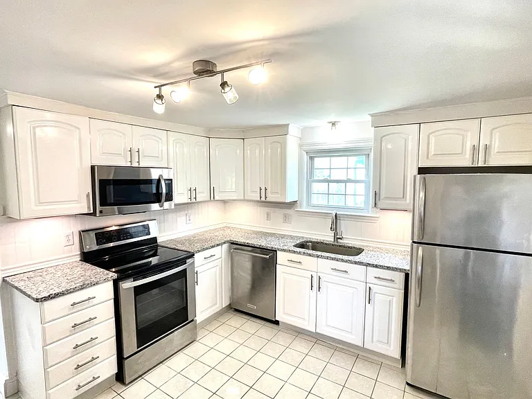 Brand new granite countertops and wainscoting backsplash and all-stainless appliances anchor the bright Kitchen.