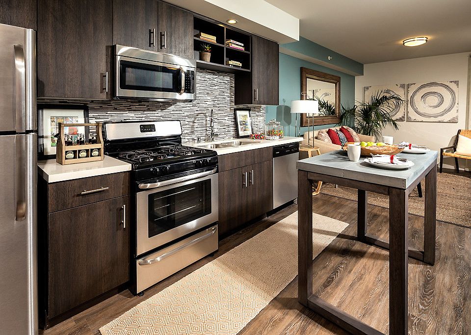 Kitchen with stainless steel appliances and hardwood style vinyl flooring.