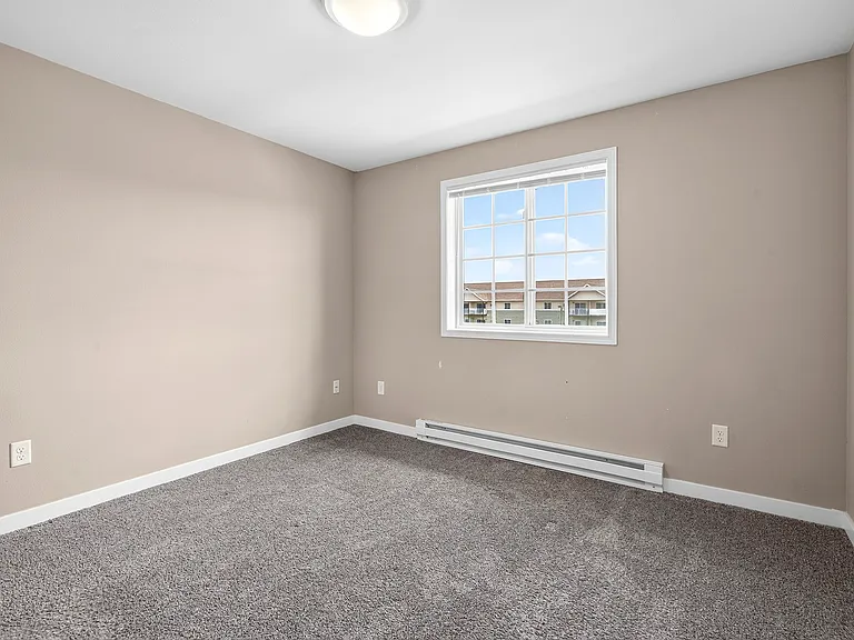 Step into comfort at Minot Place Apartments. This spacious bedroom boasts natural light, plush carpeting, and a serene atmosphere, perfect for relaxation. Don't miss out on embracing a vibrant lifestyleschedule your visit today!