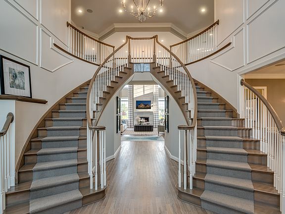 Dramatic entry foyer with dual curved staircases