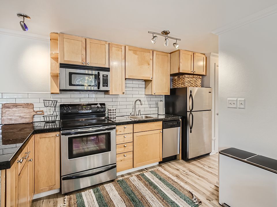 The kitchen features sleek granite tile countertops, modern subway tile backsplash, stainless steel appliances, & all the kitchen tools needed for your extended stay. There is also a full-sized pantry for extra storage.
