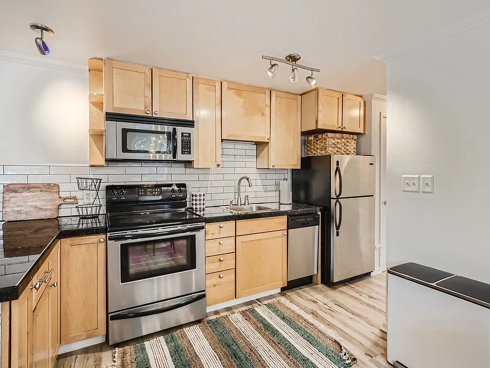 The kitchen features sleek granite tile countertops, modern subway tile backsplash, stainless steel appliances, & all the kitchen tools needed for your extended stay. There is also a full-sized pantry for extra storage.
