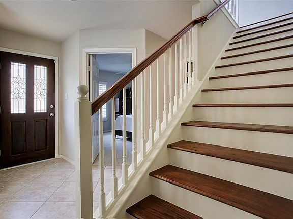 Tiled entryway and wooden stair treads lead you to the living area on the second floor.
