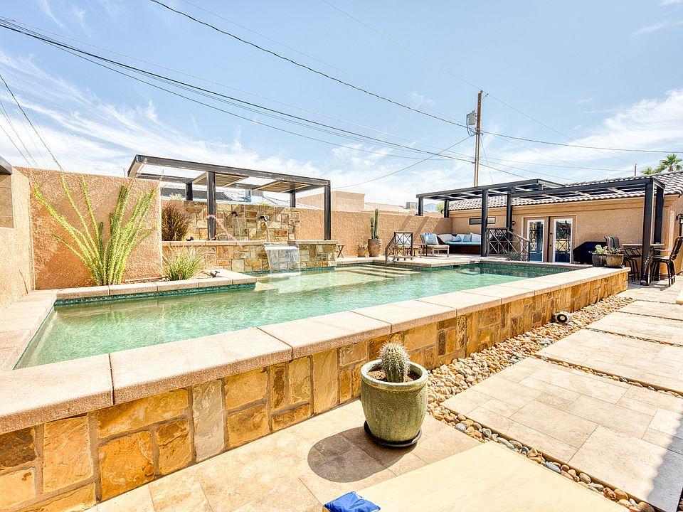 Private backyard oasis with pool, spa, fire-pit, Blackstone grill, sun deck, covered patio, outdoor dining, and lounge seating