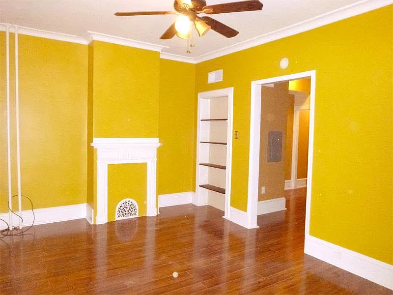 Living room with tigerwood floor, fireplace architectural design, and built-in shelves , painted in a sunny designer color (Paint color is closer to actual color in this picture and not as dark as in other pictures. Looks much nicer in person)