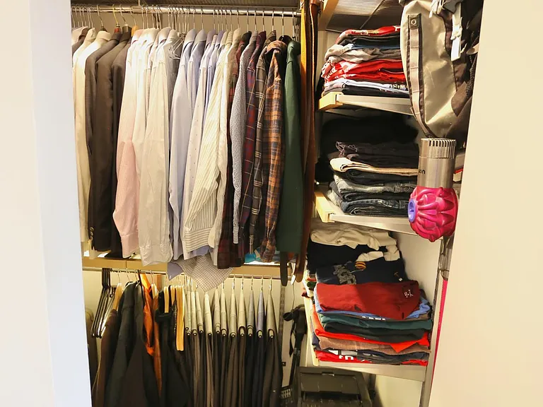 Walk-in closet with Container Store Elfa system and under-shelf lighting.