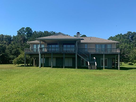 Back view of house showing back deck from living area and stairs down to ground level.