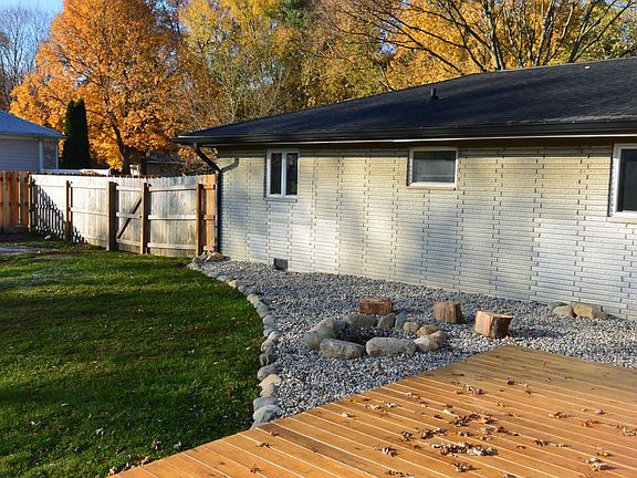 Back of home, fire pit and large wood deck.
