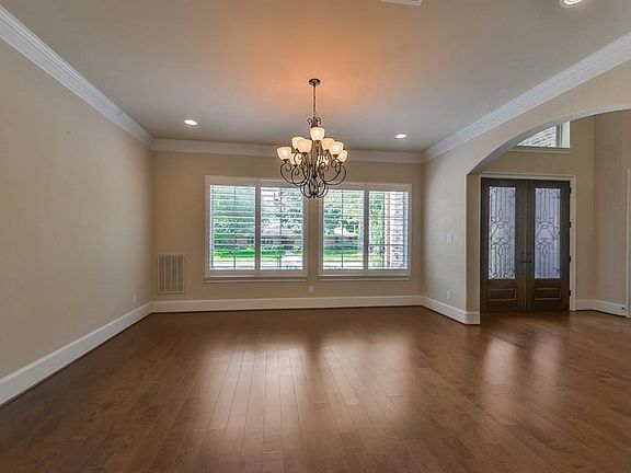 The formal dining room has engineered wood floors, crown molding and plantation shutters.