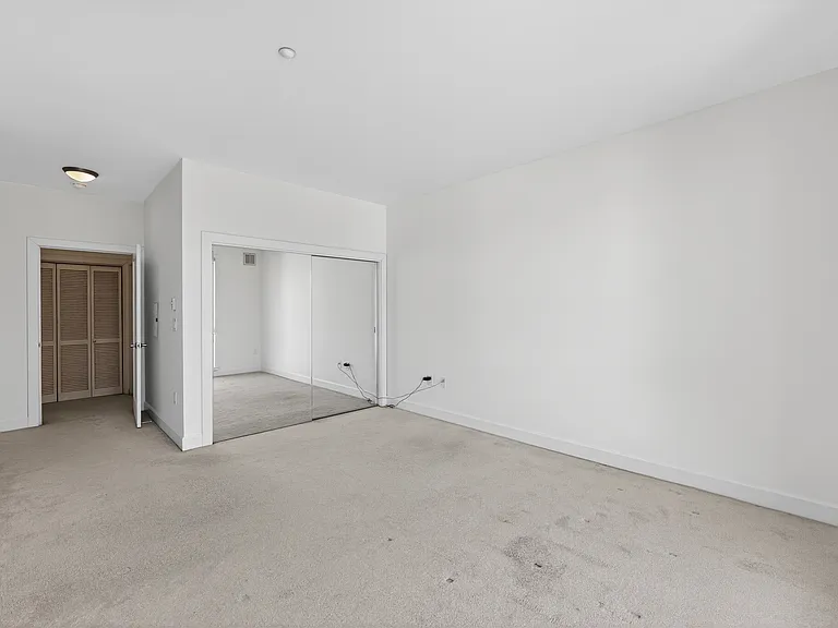 Generously sized bedroom with mirrored closet doors, professionally cleaned carpet, and room for a bed plus multiple furniture or work zones.