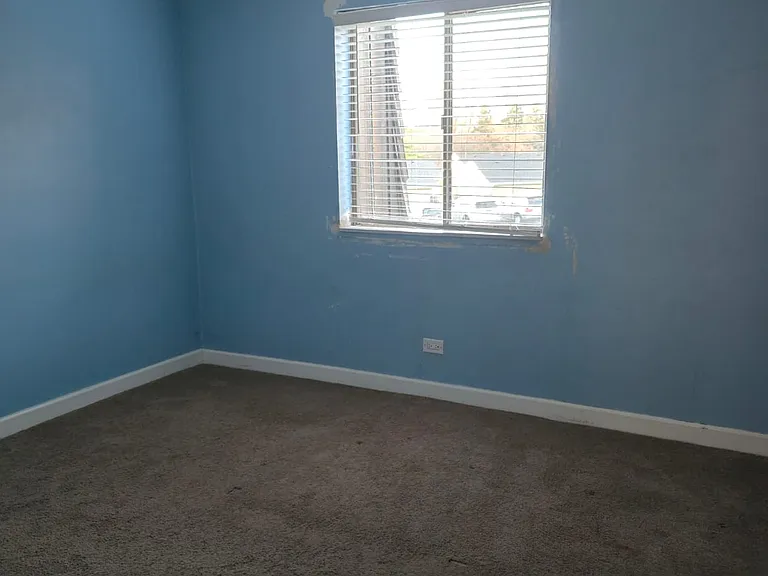 Smaller bedroom with window and a big closet.