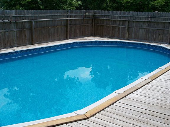 18 X 36 above ground pool with wrap-around decking and privacy fence