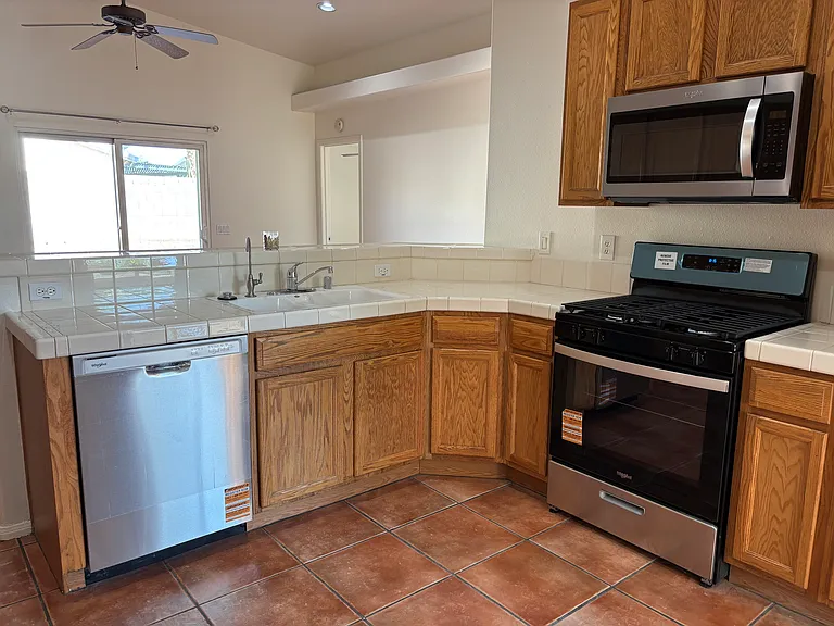 Updated kitchen with Whirlpool appliances, ample cabinet space, and an open view into the shared living space and patio area.