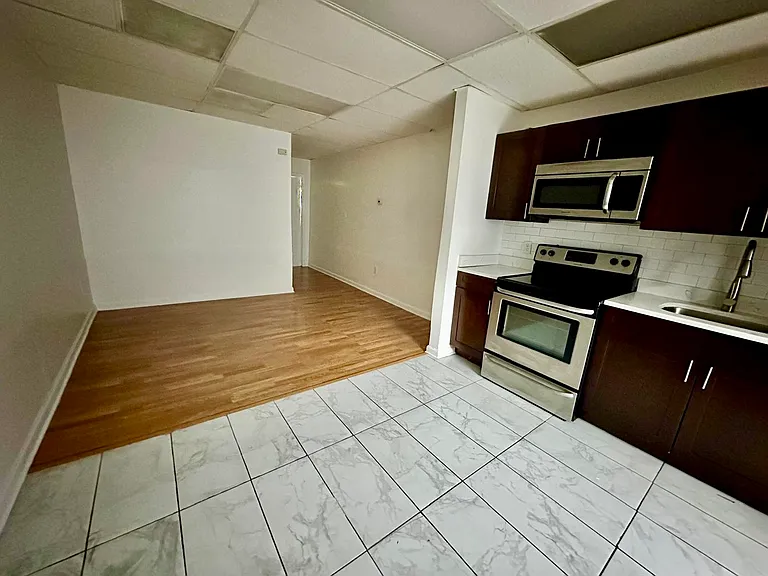 NEWLY refurbished kitchen with stainless steel appliances, tiled walls, floors, plumbing fixtures and new double pained glass windows.