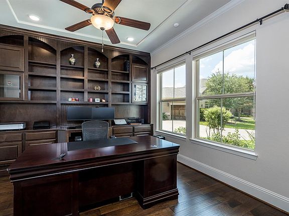The grand entry is flanked by this amazing private study with custom built-ins! Large picture windows and recessed lighting makes this the ideal place to set up your home office!