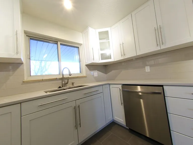 Samsung Stainless StormWash Dishwasher, next to deep stainless sink and topped with Quartz Countertops.