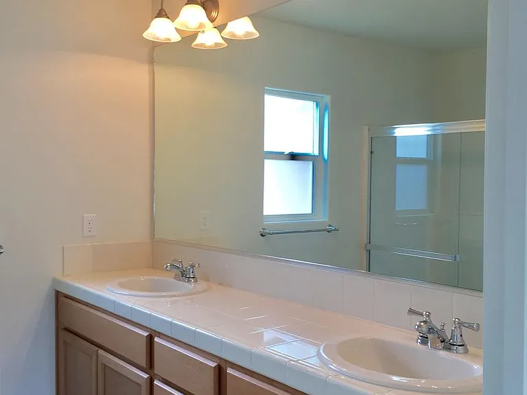 Master bathroom has dual sink, plenty of natural lighting and storage cabinets.