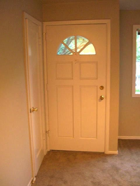 Inside view of front door with arched window and deadbolt.