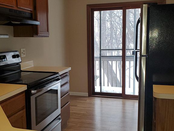 Kitchen & breakfast nook, with patio door/balcony. Wooded view with park visible from balcony.