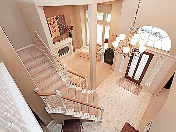 OPEN THE UPGRADED FRONT DOOR TO THE SOARING BRIGHT FOYER WITH TILE FLOORS AND A LOVELY CHANDELIER