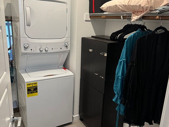 Walk in closet features stackable washer and dryer.
