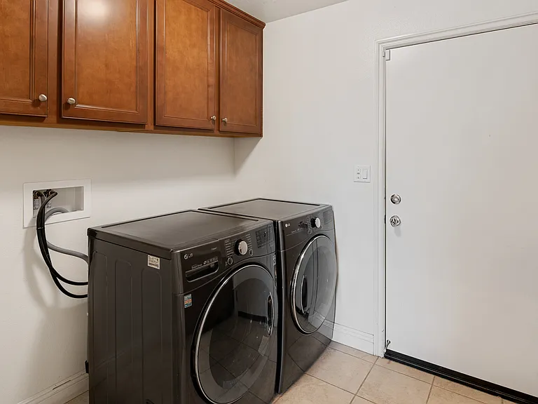 Separate Laundry Room Downstairs with lots of cabinets and Upgraded Washer and Dryer Included.