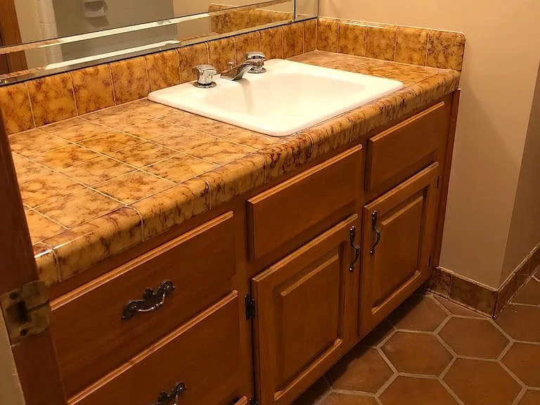 Upstairs hall bath with tub tile floor & tile counter with huge mirror