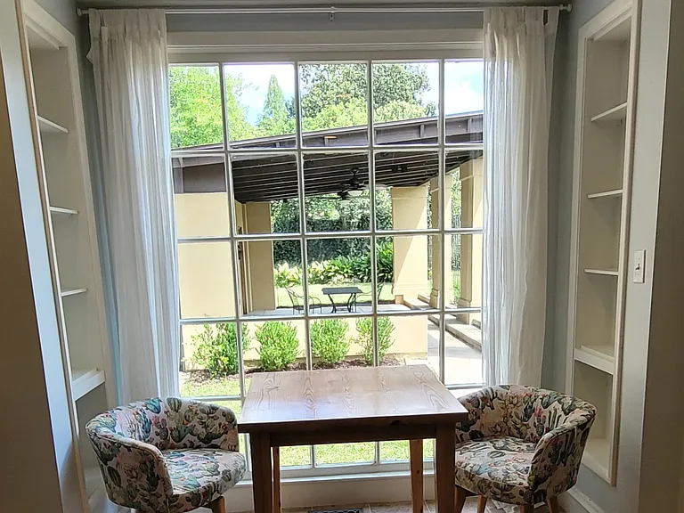 Breakfast nook with backyard view and built-in shelves. Furniture for staging purposes.