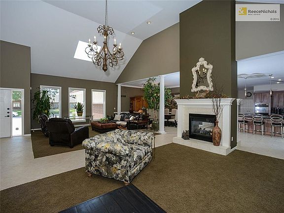 View of tiled entry, the living room(s), see-through fireplace, vaulted ceiling with skylight, dining room, breakfast area and kitchen - AMAZING.
