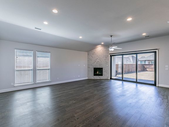Large Family Room/with gas fireplace and expansive sliding glass doors with automatic shades. Amazing natural light.