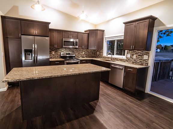 Kitchen with sliding glass doors and elevated porch overlooking open space.